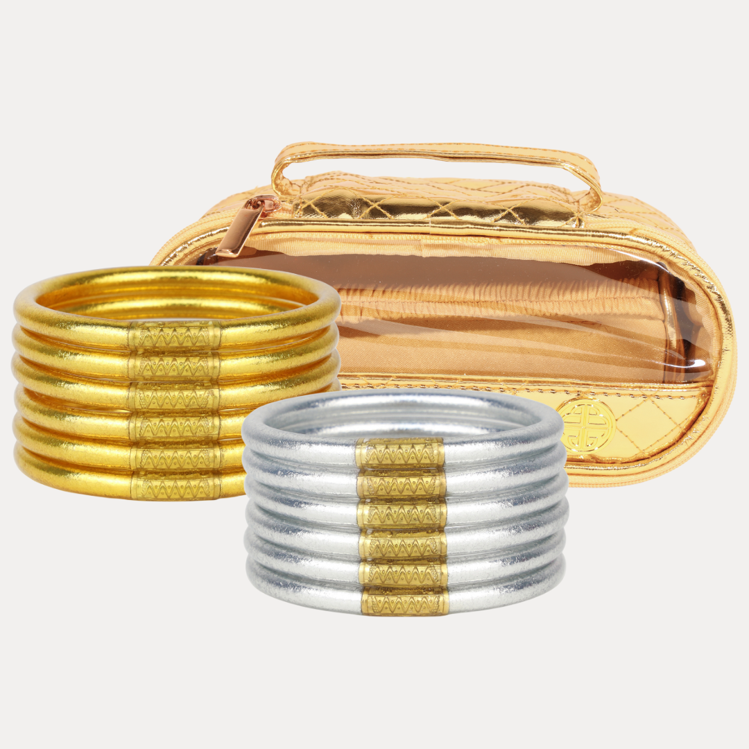 Gold and silver bangles with a gold case on a white background